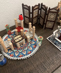 Decorative setup with spools of thread, a small table, and a decorative screen on a wooden surface.