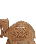 Close-up of handcrafted wooden camel with engraved geometric design