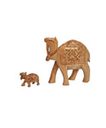 A carved wooden figurine of a camel, with a smaller, carved camel figure beside it.