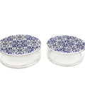 Set of glass containers with blue and white patterned lids on a white background