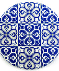 Round tile with blue and white decorative pattern on a white background