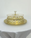Decorative glass cake stand with gold accents on a white surface