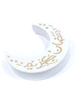 A white porcelain canister with a gold hand-painted moon and stars design, with the phrase 'Ramadan Kareem'.