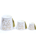 A white porcelain jar with gold hand-painted decorations, including a fez-shaped lid and a gold tassel.