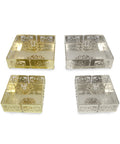 Four square glass coasters with decorative patterns on a white background