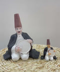 Figurine of a seated man playing the tambourine in oriental attire – rhythmic Arabic décor from the FERQA Collection.