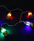 String of gold lantern-shaped lights on a dark blue fabric background