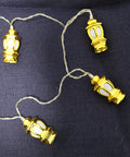 String of gold lantern-shaped lights on a dark blue fabric background