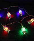 String of gold lantern-shaped lights on a dark blue fabric background