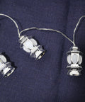 String of silver lantern lights on a dark blue fabric background