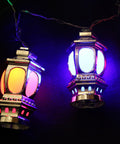 Gold lantern-shaped string lights on a dark blue fabric background