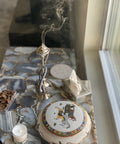 Decorative incense holder with smoke on a reflective surface