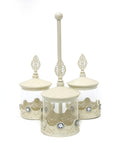 Three metal and glass jars connected with a vertical handle, used for serving different treats.