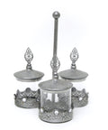 Three metal and glass jars connected with a vertical handle, used for serving different treats.