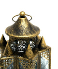 Decorative brass lantern with intricate designs on a white background