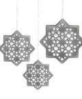 Three silver geometric star-shaped decorations hanging against a white background